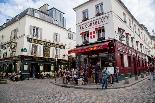 Paris, France - May 12, 2017: The streets of Montmartre district with people sitting in cafes and restaurant