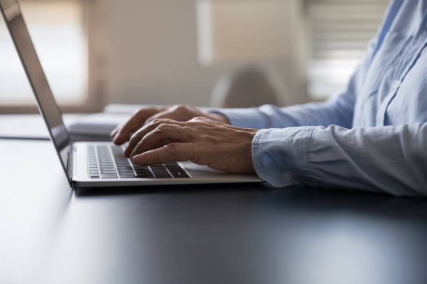 istock Closeup older female hands typing on modern laptop keyboard 1435621745