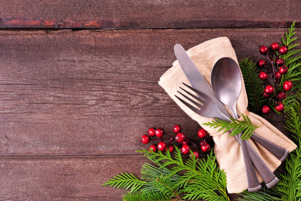 istock Christmas or winter table setting corner border with evergreen branches and red berries on a rustic wood background 1435623747