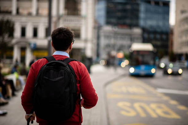 young it expert waiting for a bus to go to work - color image bus discussion expertise imagens e fotografias de stock