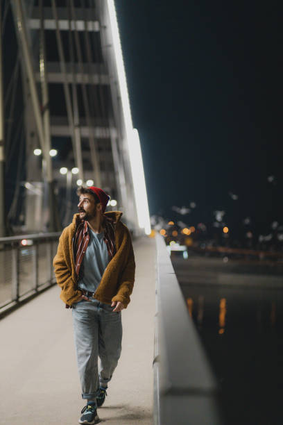 istock Fashionable young man walking down the bridge 1435623800
