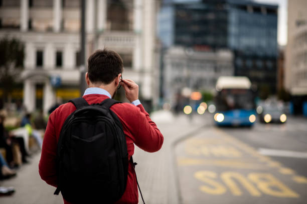 male student waiting for his bus to university - color image bus discussion expertise imagens e fotografias de stock