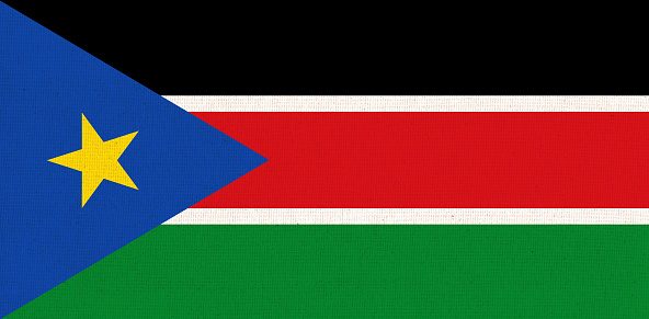 Flag of South Sudan. South Sudanian flag on fabric surface. Fabric texture. National symbol of South Sudan on patterned background. Republic of South Sudan
