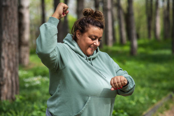 istock Obese woman smiling after checking workout results on smart watch 1435624914