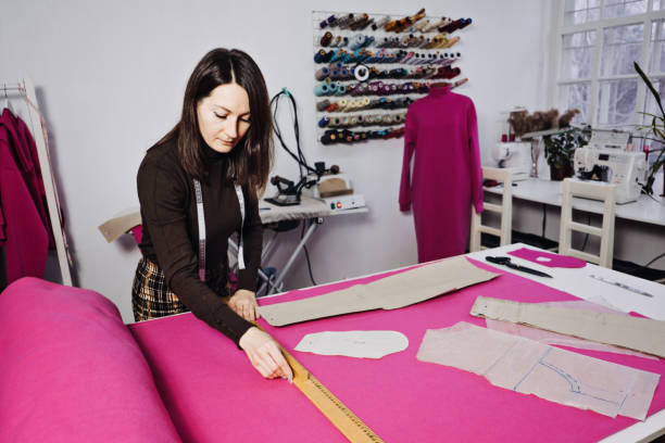 istock Seamstress working with sewing pattern on table in tailor shop 1435627219