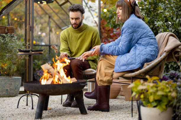istock Young couple spending dinner time by the fire at backyard 1435628363