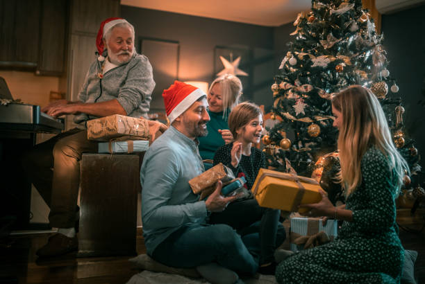 семья из нескольких поколений в гостиной с рождественскими подарками - caucasian child offspring color image стоковые фото и изображения