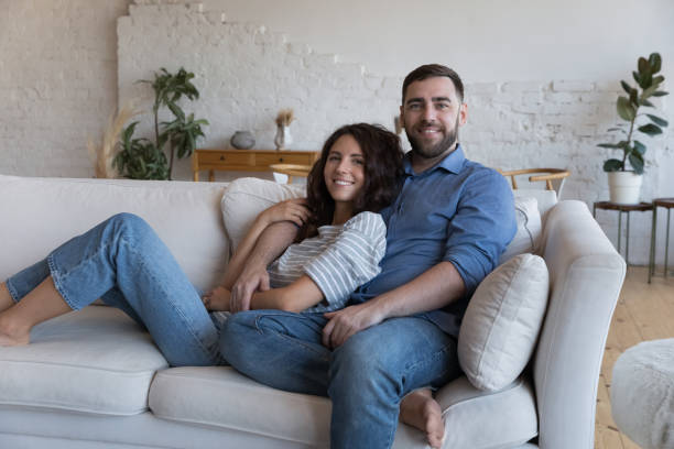 istock Multi-ethnic couple relaxing on comfortable couch smile pose for camera 1435630863