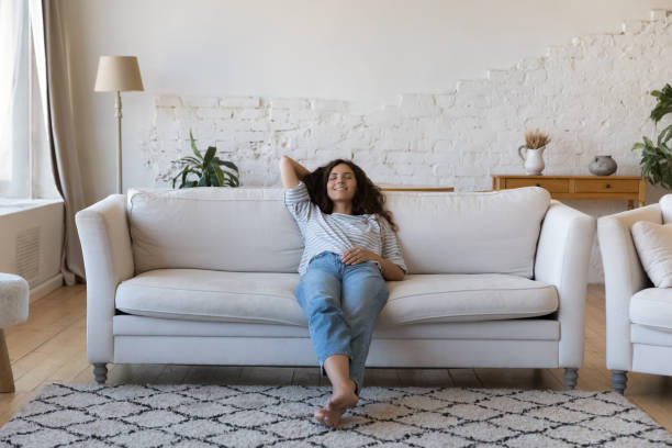 Pretty Latina woman relaxing on sofa at home stock photo