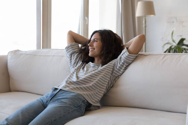 istock Peaceful woman relaxing on soft comfortable couch at home 1435630993