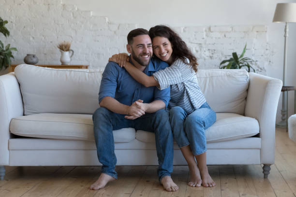 istock Romantic couple hugging seated on sofa at home 1435631000