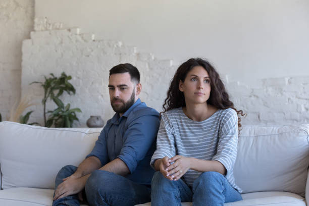 istock Silent couple sit on sofa staring aside after fight 1435631003