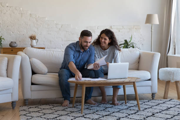 Wife and husband pay bills, sorting out papers feel satisfied