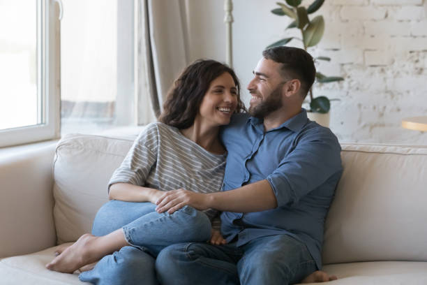 istock Couple in love sit on sofa enjoy weekend at home 1435631735
