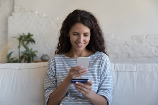 istock Young woman make purchase online use debit card and smartphone 1435633644
