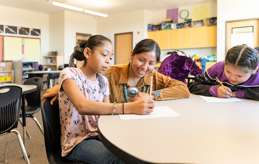 Indigenous navajo teacher helping students with their work