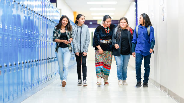 High schoolers walking on a corridor at school stock photo