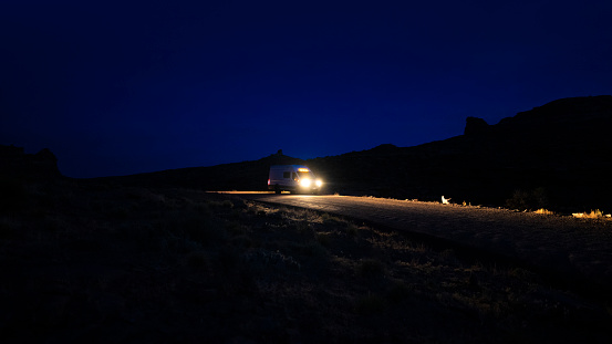 Van driving down a dirt road at night in Utah, USA