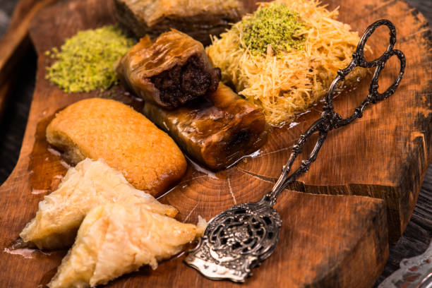 istock Ramadan Kareem, traditional Turkish middle eastern Iftar sweets Baklava with pistachios and fresh honey on rustic wooden plate and vintage blue background table. Top view. 1435644824