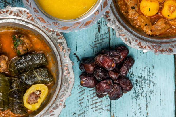 istock Eid Mubarak Traditional Ramadan Iftar dinner. Assorted tasty food in authentic rustic dishes on wooden blue background. Turkish Bosnian food meat kebab, pita, Sarma, klepe, sogan dolma. 1435645941