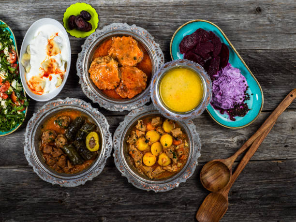 istock Eid Mubarak Traditional Ramadan Iftar dinner. Assorted tasty food in authentic rustic dishes on wooden blue background. Turkish Bosnian food meat kebab, pita, Sarma, klepe, sogan dolma. 1435648108