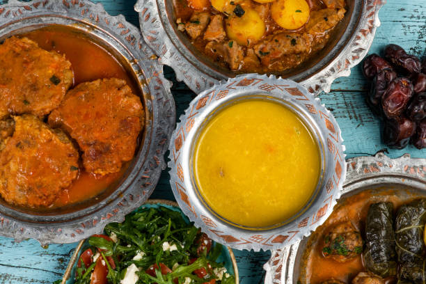 istock Eid Mubarak Traditional Ramadan Iftar dinner. Assorted tasty food in authentic rustic dishes on wooden blue background. Turkish Bosnian food meat kebab, pita, Sarma, klepe, sogan dolma. 1435648505