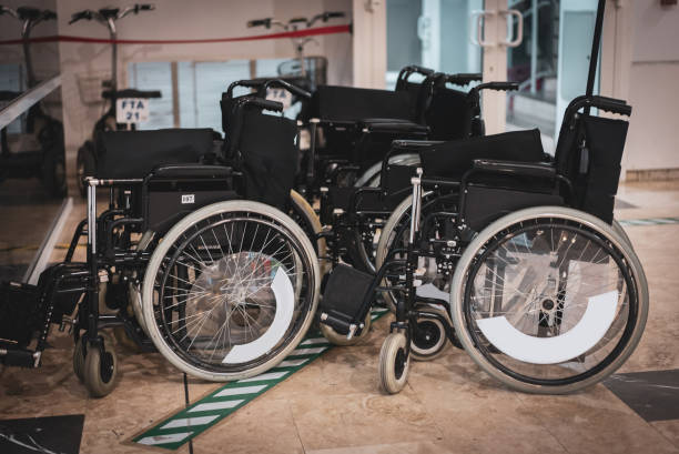 Row of empty wheelchairs in airport hall.