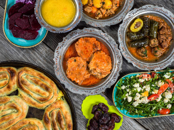 istock Eid Mubarak Traditional Ramadan Iftar dinner. Assorted tasty food in authentic rustic dishes on wooden blue background. Turkish Bosnian food meat kebab, pita, Sarma, klepe, sogan dolma. 1435650429