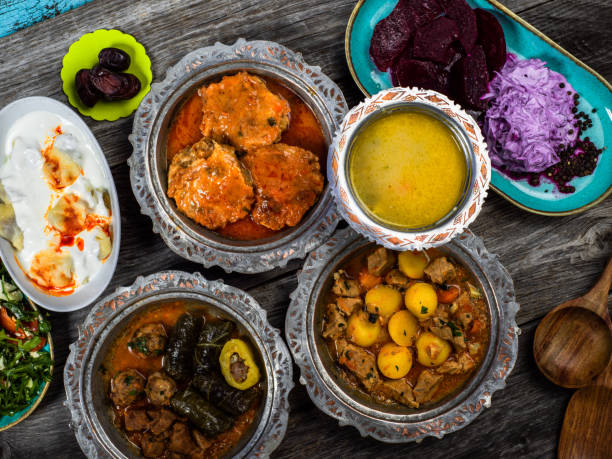 istock Eid Mubarak Traditional Ramadan Iftar dinner. Assorted tasty food in authentic rustic dishes on wooden blue background. Turkish Bosnian food meat kebab, pita, Sarma, klepe, sogan dolma. 1435651910