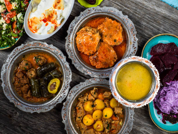 istock Eid Mubarak Traditional Ramadan Iftar dinner. Assorted tasty food in authentic rustic dishes on wooden blue background. Turkish Bosnian food meat kebab, pita, Sarma, klepe, sogan dolma. 1435652737