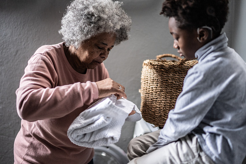 Grandmother and grandson washing clothes in the laundry at home