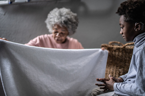 Grandmother and grandson washing clothes in the laundry at home