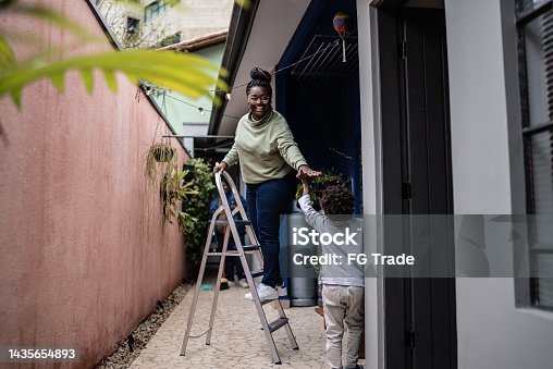 istock Mother holding the hands her son in the yard at home 1435654893