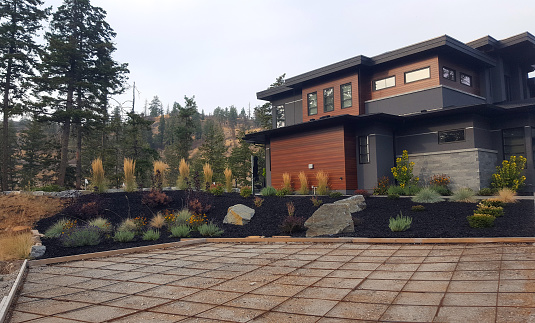Vernon, British Columbia, Canada- October, 7,2022: Exterior of new modern home with new landscaping and beginning construction of a new driveway with Rebar.