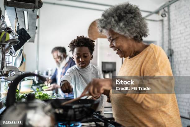 Grandson Helping His Grandmother Cooking At Home Stock Photo - Download Image Now - Family, Cooking, Senior Adult