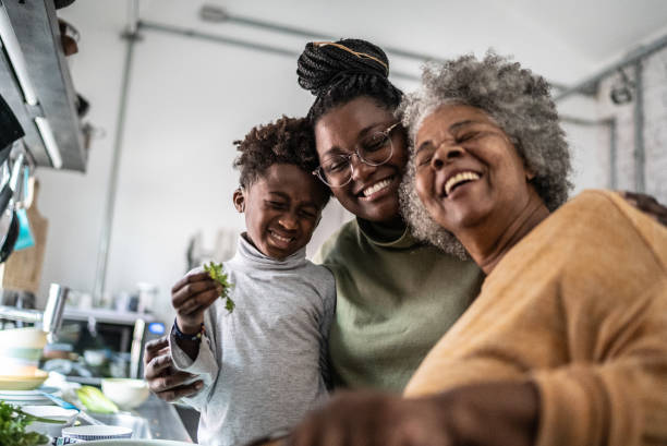 happy family cooking at home - grandparent senior adult senior women multi generation family imagens e fotografias de stock