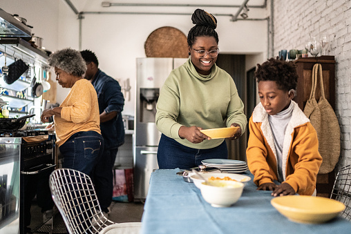 Family setting the table and preparing the lunch at home