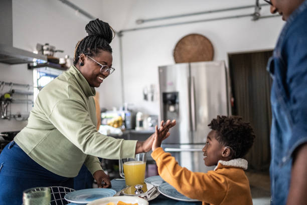 istock Mother and her son doing a high-five after organizing the table for lunch at home 1435656604