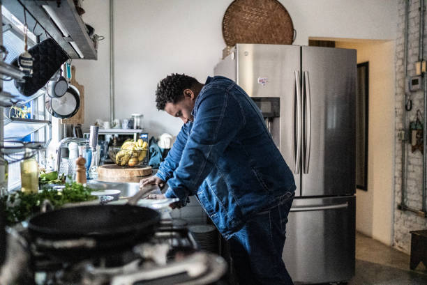 triste hombre adulto medio en la cocina de casa - agotamiento fotografías e imágenes de stock