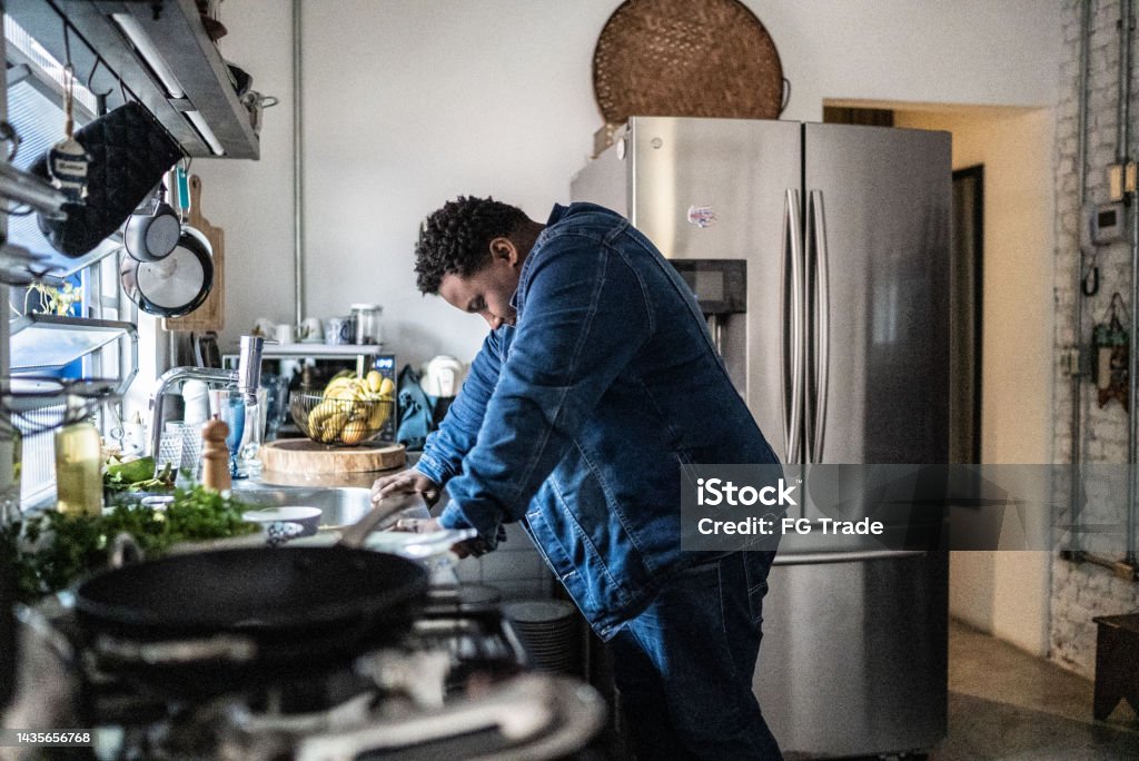 Sad mid adult man in the kitchen at home Tired Stock Photo