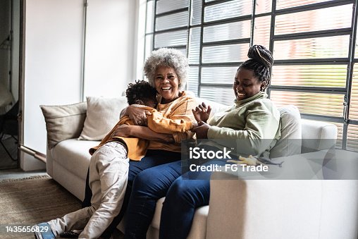 istock Child playing with his mother and grandmother in the living room at home 1435656829