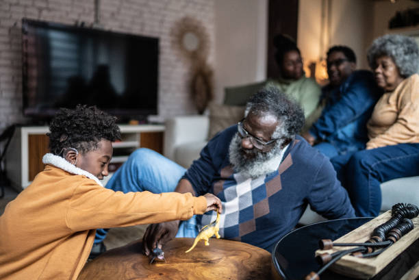 Grandparents and their little grandchild play happily in the living room of the house