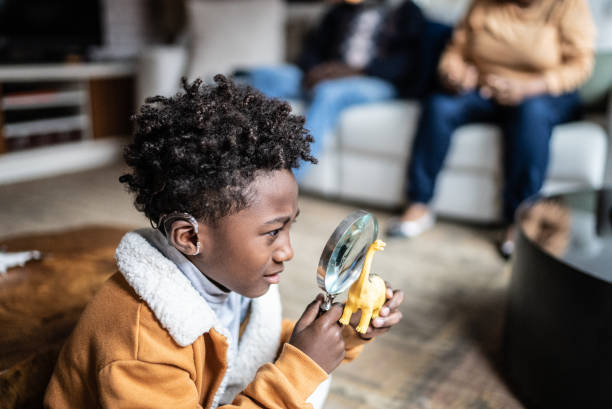 Child looking a toy with a loupe at home