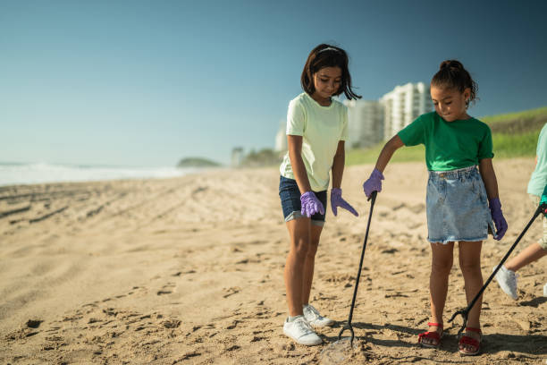 istock Girls collecting garbage at the beach 1435661783