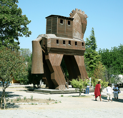 Canakkale, Turkey - July 28, 2012: Tourist poses in the wooden horse which made by turkish carpenter Ahmet Karadeniz. It's used for describing Troy. It was given to the city of Canakkale as a present in 2004. Now, it is located and displayed at a public park near the coast of Canakkale city in Turkey.