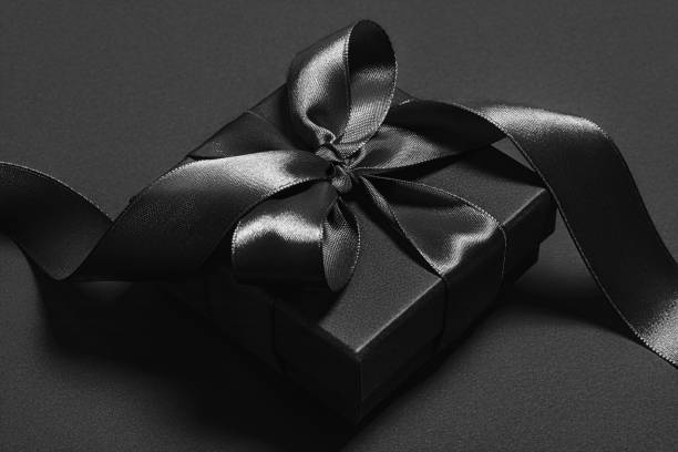 istock Black gift box with black ribbon on a black background. 1435661831