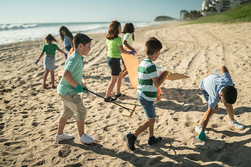 Brigade of children recyclers picking up trash at the beach