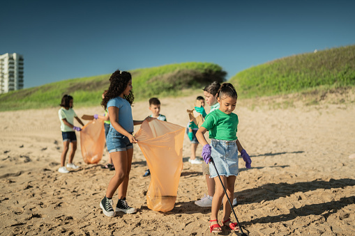 Brigade of children recyclers picking up trash at the beach