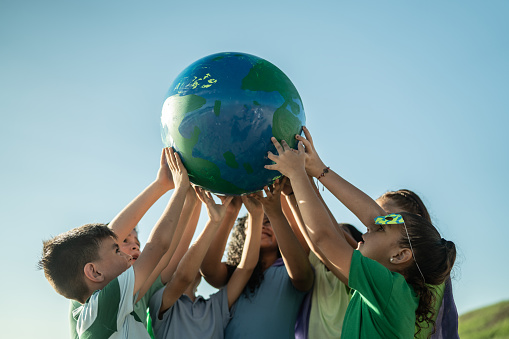 Hands holding an earth on an out-of-focus background of green plants, Concept of the Environment , World Earth Day.