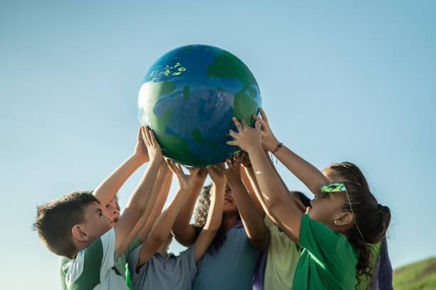 children holding a planet outdoors - earth globe human hand symbols of peace imagens e fotografias de stock